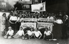 109196 Afbeelding van ijscokarren van de firma MOBA met rechts de verkoper Wim Jacobs in wit uniform, te midden van ...
